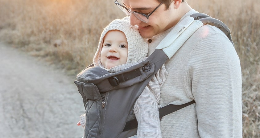 Dad carrying baby with Huggs Carrier