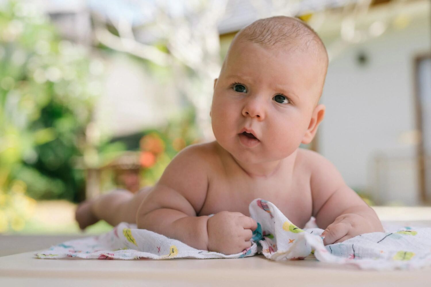 baby doing tummy time on blanketed floor