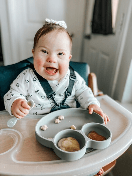 down syndrome babysitting in a high chair using feeding therapy tools