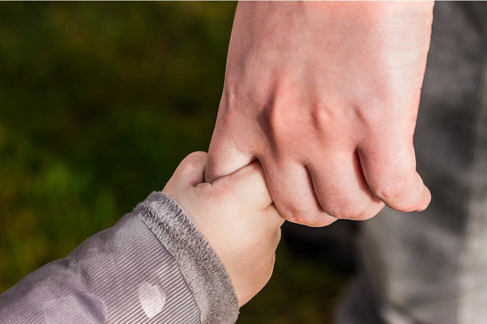 Parent and infant holding hands