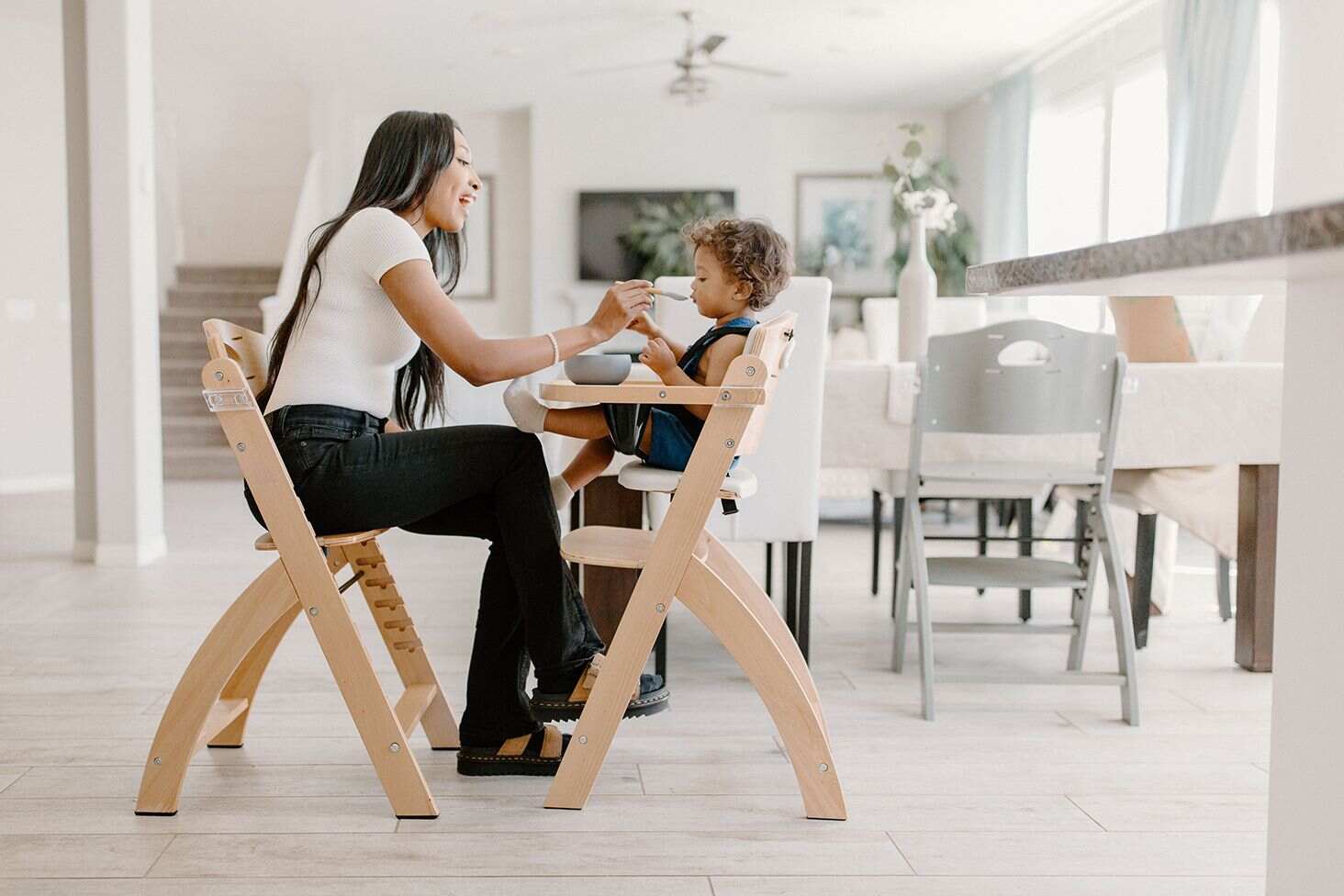 woman feeding baby on beyond junior high chair